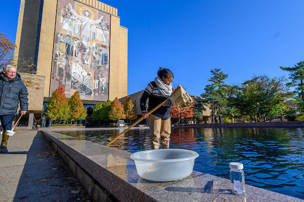 Graduate students in Ron Hellenthal's Aquatic Insects class take samples of insects from the library reflecting pool on the day it is drained for the year.