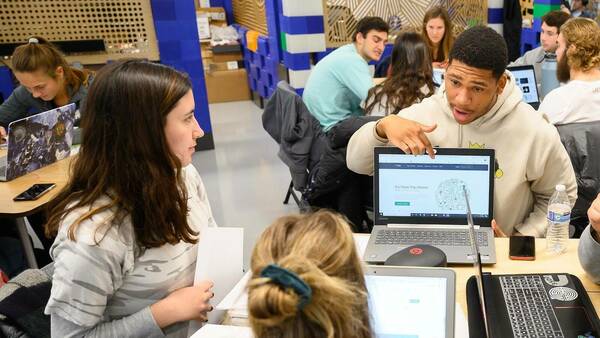Students discuss a project in the Intro to Entrepreneurship class in the innovation lab at the Notre Dame IDEA Center.